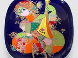 une image représentant une assiette décorative sur laquelle figure une femme jouant d'un instrument de musique