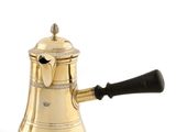 une cafetière ancienne en laiton avec une poignée noire sur fond blanc