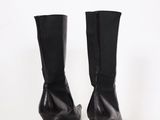 pair of black leather high heeled boots on a white surface