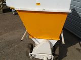a yellow and white spreader sitting outside of a building