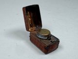 a small wooden box with a small metal object inside of it