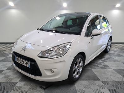 la petite voiture blanche est garée sur un sol en damier