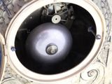 a silver clock with a silver ball inside of it