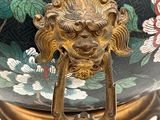 a vase with a lion head on it sitting on a stand