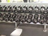 a row of dumbs in a gym with a rack of dumbs