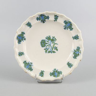 assiette bleue et blanche ornée de fleurs bleues sur le bord