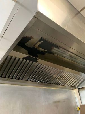 une photo d'une cuisine équipée d'une hotte en acier inoxydable