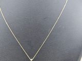 a gold necklace with a key pendant on a mannequin mannequin