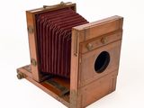 an old camera that is sitting on a wooden stand