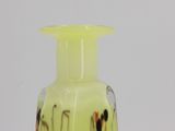 a yellow glass vase with black and red designs on it