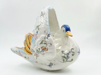 un oiseau en céramique posé sur une surface blanche