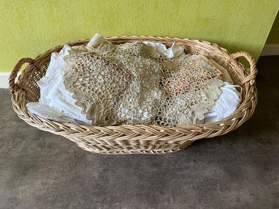 un panier en osier posé par terre, contenant un peu de pain