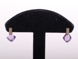 pair of purple and white crystal earrings on a black display stand