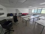 des tables et des chaises dans une pièce donnant sur une grande fenêtre