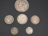 six different british coins are arranged in a circle on a black surface
