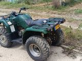 une photo d'un quad vert garé sur le bord de la route