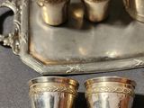 a silver tray with silver cups and a silver tea pot