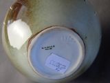 a close up of a vase with a tag on it