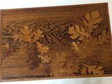a wooden box with a design of leaves on it