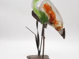 une sculpture en verre représentant un oiseau perché sur un rocher