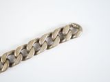 a close up of a silver bracelet on a white surface