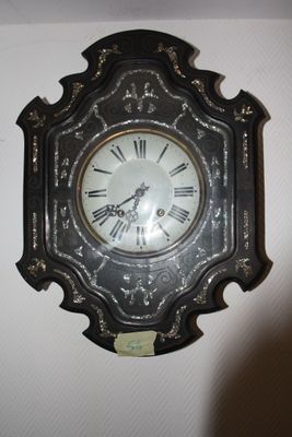 a clock hanging on the wall with roman numerals on it