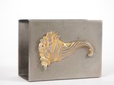 silver and gold metal box with a decorative design on the front