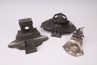 trois objets métalliques posés sur une surface blanche