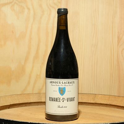 a bottle of wine sitting on top of a wooden barrel
