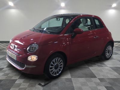 la petite voiture rouge est garée sur un carrelage à carreaux