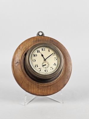 une horloge en bois posée sur un socle, sur fond blanc