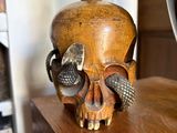 a wooden skull on a shelf next to a book shelf