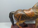 a wooden horse with a saddle on it ' s back