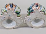 pair of ceramic vases with colorful designs on them sitting on a white surface