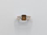 a close up of a ring with a brown stone on it