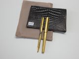 deux stylos et un portefeuille posés sur une surface blanche