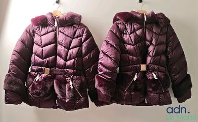 deux vestes violettes accrochées à un mur, avec un mur blanc en arrière-plan