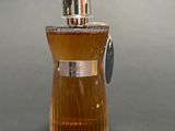 a bottle of perfume on a table with a gray background