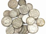 une pile de pièces d'argent posée sur une surface blanche