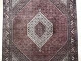 an oriental rug with a diamond design on a white tile floor