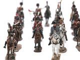 many figurines of men riding horses on a white surface