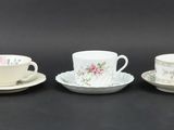 three cups and saucers sitting on top of a black table