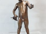une statue en bronze représentant un garçon tenant une fleur