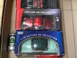 two boxes of toy cars and a can of soda on the floor