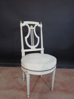 une image représentant une chaise blanche avec une harpe sur le dossier