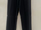 a black pants hanging on a hanger on a wall
