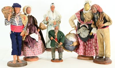 five figurines of people dressed in different costumes