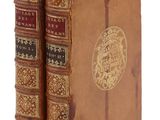 deux vieux livres posés l'un sur l'autre sur une surface blanche
