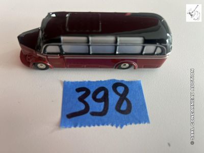 un petit bus en jouet posé à côté d'une feuille de papier