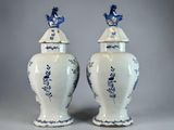 pair of blue and white vases with birds on top of them